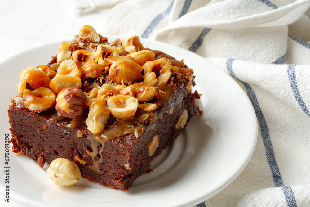 Piece of brownie cake with hazelnuts on white background Piece of brownie cake with hazelnuts on white background