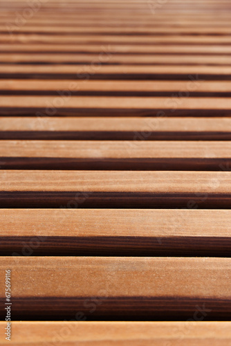 Background made of new smooth wooden slats. Close-up. A receding perspective. Selective focus.