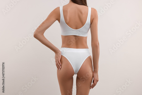 Young woman in stylish bikini on white background, closeup