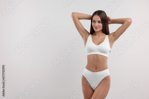 Young woman in stylish bikini on white background