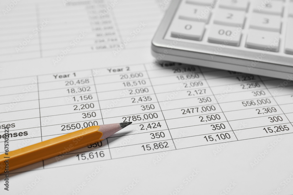 Calculator and pencil on document with data, closeup view Calculator and pencil on document with data, closeup view