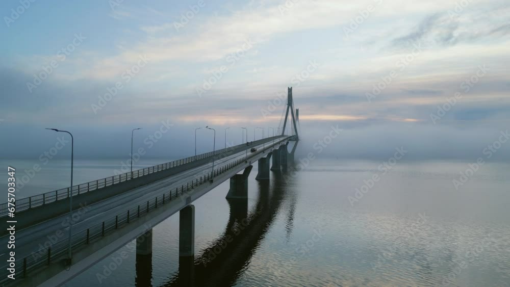Establishing aerial shot of Replot bridge in Finland at dawn, car passing by