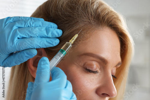 Trichologist giving injection to patient in clinic  closeup