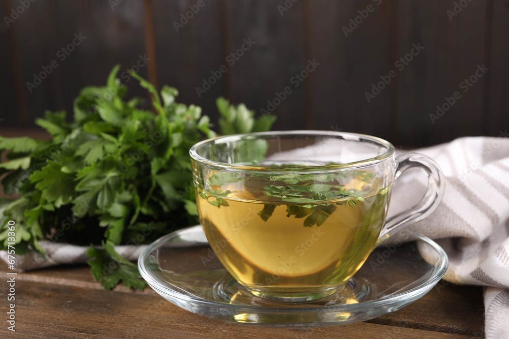 Aromatic herbal tea with parsley on wooden table, closeup Aromatic herbal tea with parsley on wooden table, closeup