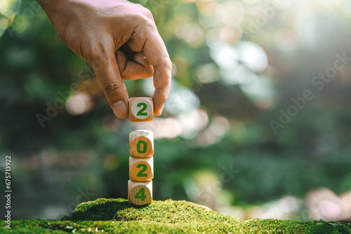 ESG concept ,Sustainable development goalStart a new year 2024 to achieve business goals environment (SDGs) Ideas for wood cube block on a green forest nature SDGs, ESG, NetZero, and co2 concept