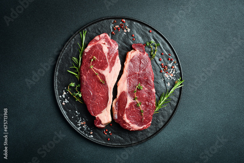 Bild auf Leinwand Two raw rib eye beef steaks with spices on a plate