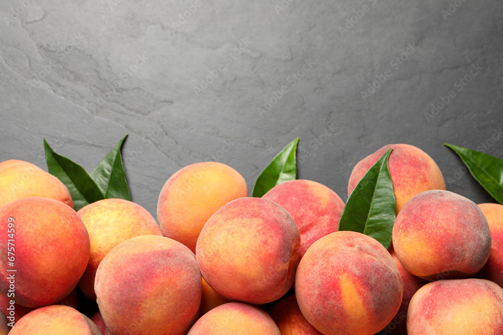 Fresh peaches and leaves on dark grey textured table, flat lay. Space for text Fresh peaches and leaves on dark grey textured table, flat lay. Space for text