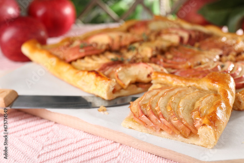 Freshly baked apple pie with knife on table, closeup