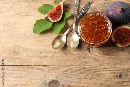 Fototapeta Naklejka Na Ścianę i Meble -  Glass jar with tasty sweet jam, spoons and fresh figs on wooden table, flat lay. Space for text