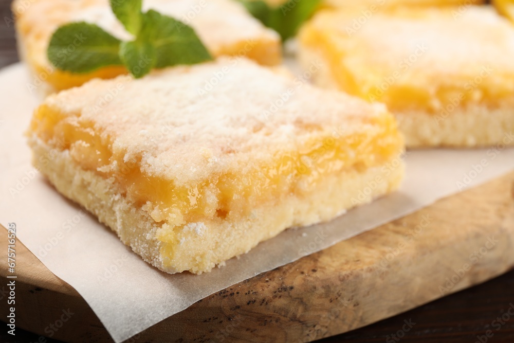 Tasty lemon bar with powdered sugar and mint on board, closeup Tasty lemon bar with powdered sugar and mint on board, closeup