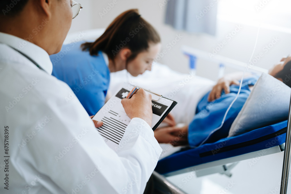 Fototapeta premium Two doctors talking to a patient lying in his bed with receiving saline solution