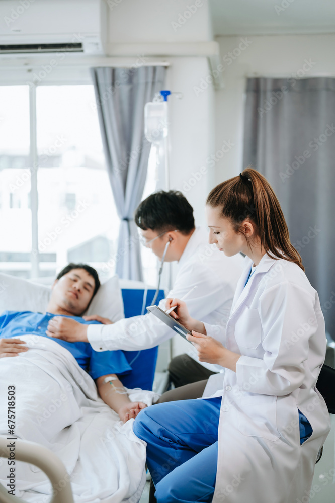 Two doctors talking to a patient lying in his bed with receiving saline solution in hospital . Two doctors talking to a patient lying in his bed with receiving saline solution in hospital .