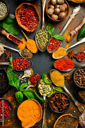 Set of Indian colored spices and seasonings in spoons. Vertical photo. Top view.