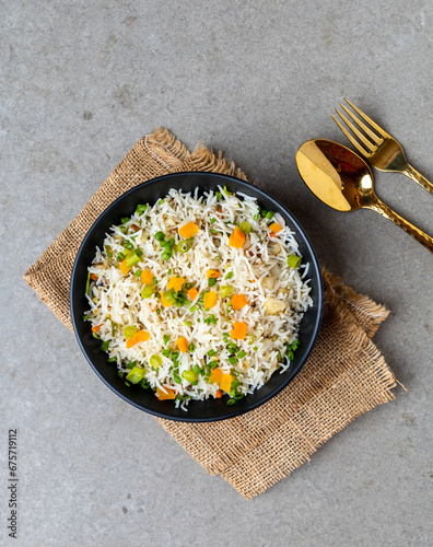 Authentic Chinese and Asian fried rice with egg and vegetables in ceramic brown bowl top view .Traditional dish of China with space for text.