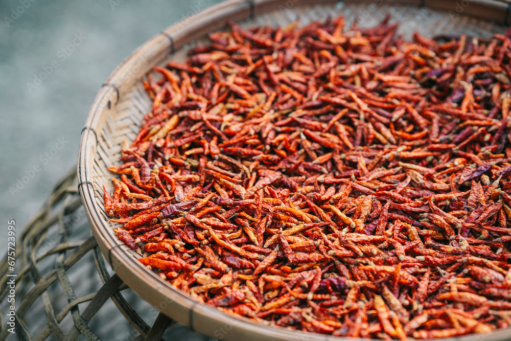 Dried red chilies in a wooden basket to be used as a seasoning in food. Dried red chilies in a wooden basket to be used as a seasoning in food.