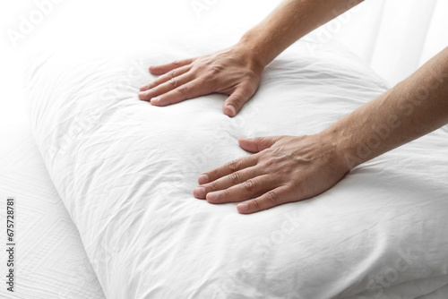 hands of a man folding a white blanket on the bed. selective focus . High quality photo