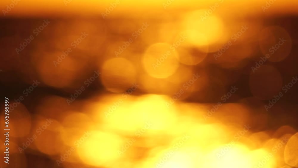 Blurred golden sea at sunset. The sun reflects and sparkles on the waves with bokeh, illuminating the golden sea. Holiday recreation concept. Abstract nautical summer ocean sunset nature background. Blurred golden sea at sunset. The sun reflects and sparkles on the waves with bokeh, illuminating the golden sea. Holiday recreation concept. Abstract nautical summer ocean sunset nature background.
