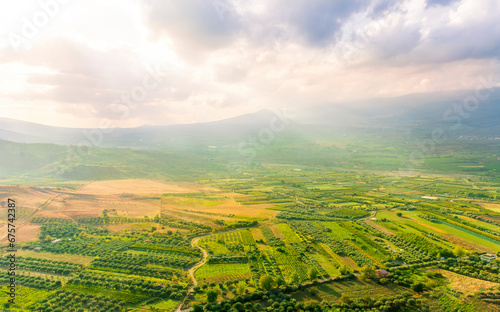 rustic landscape view of rural green valley in mountain hills with farms and gardens