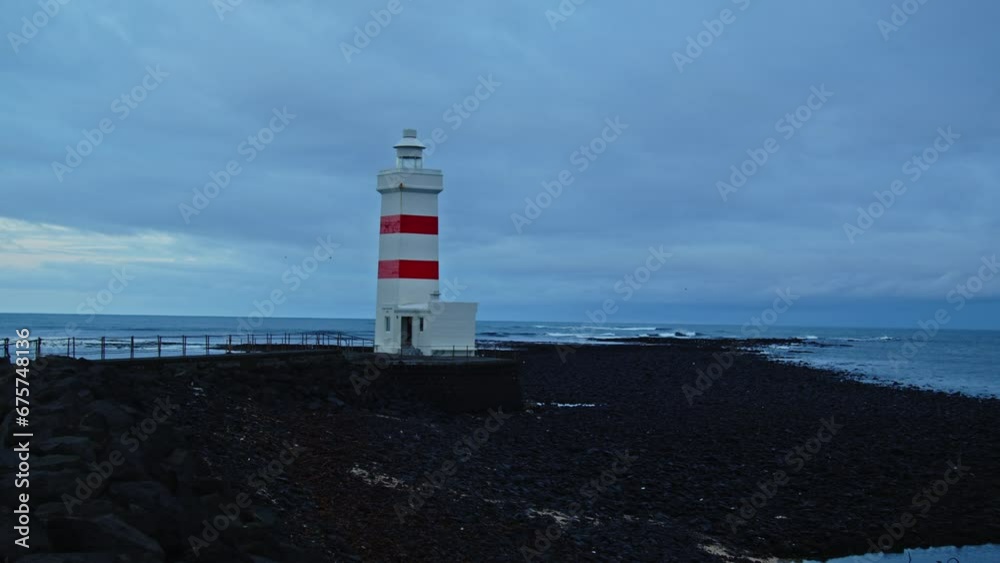 Pan of beautiful old lighthouse on a small peninsula in Iceland Pan of beautiful old lighthouse on a small peninsula in Iceland