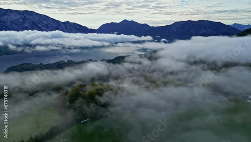 Aerial view backwards over low hanging clouds at lake Attersee, in Austria photo