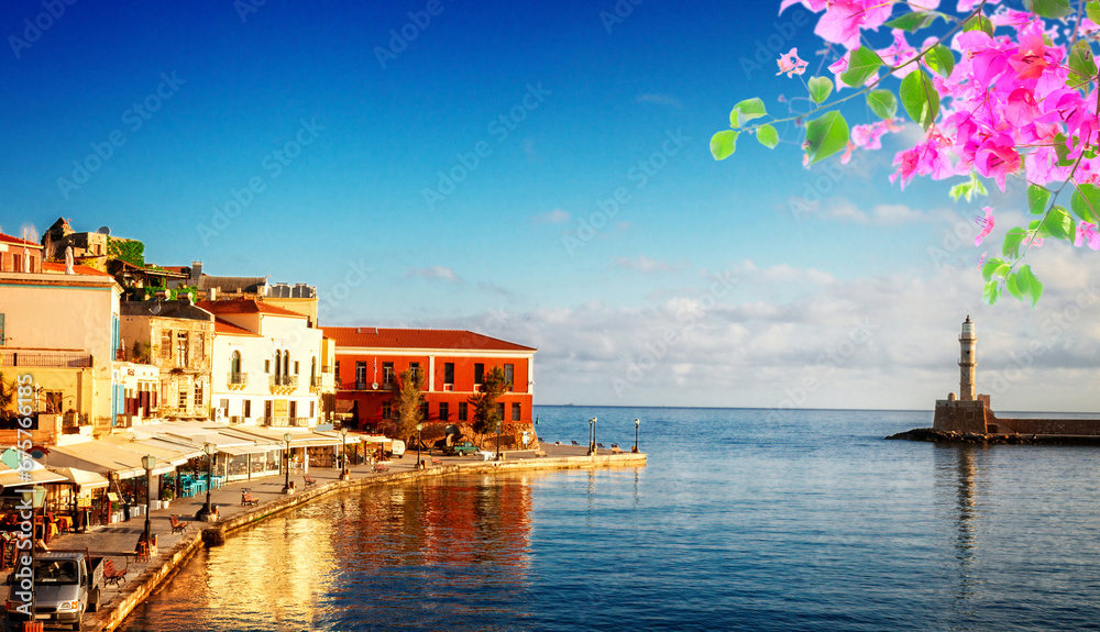 Obraz premium famouse venetian harbour waterfront and lighthouse of Chania old town, Crete, Greece with flowers
