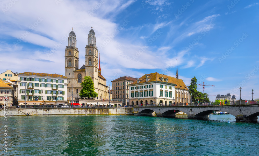 View of the Wasserkirche, Grossmunster and Limmat river with unknown people. Canton of Zurich, Switzerland. A walk through the city on a sunny day