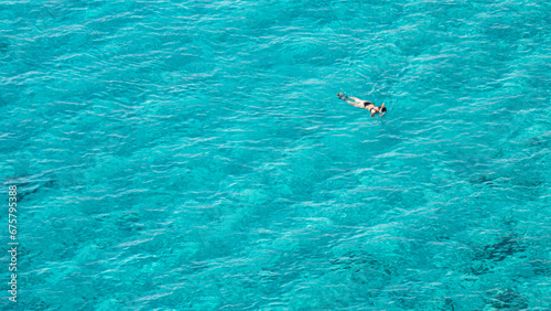 Close shot of girl diving and snorkling in beautiful blue sea with calm waves with space for design 