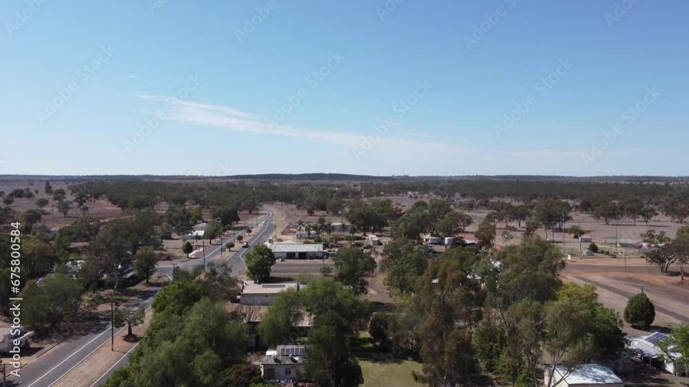 Drone taking off in a small town showing a passing through highway with a car Drone taking off in a small town showing a passing through highway with a car