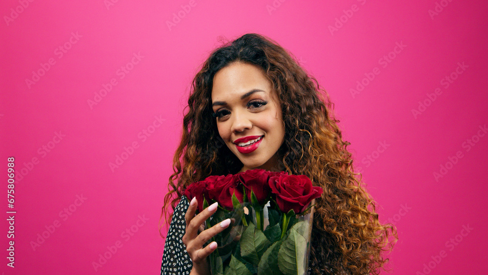 Beautiful multi-ethnic woman holds bunch of red roses, romance, pink studio Beautiful multi-ethnic woman holds bunch of red roses, romance, pink studio
