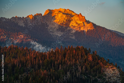 An orange mountain peak of Sierra Nevada mountains viewed from Moro Rock in Sequoia National Park during sunset. photo