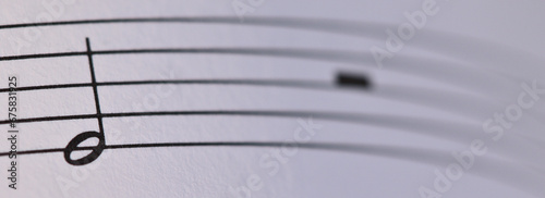 Partitura solfeo: nota musical blanca y silencio.  photo