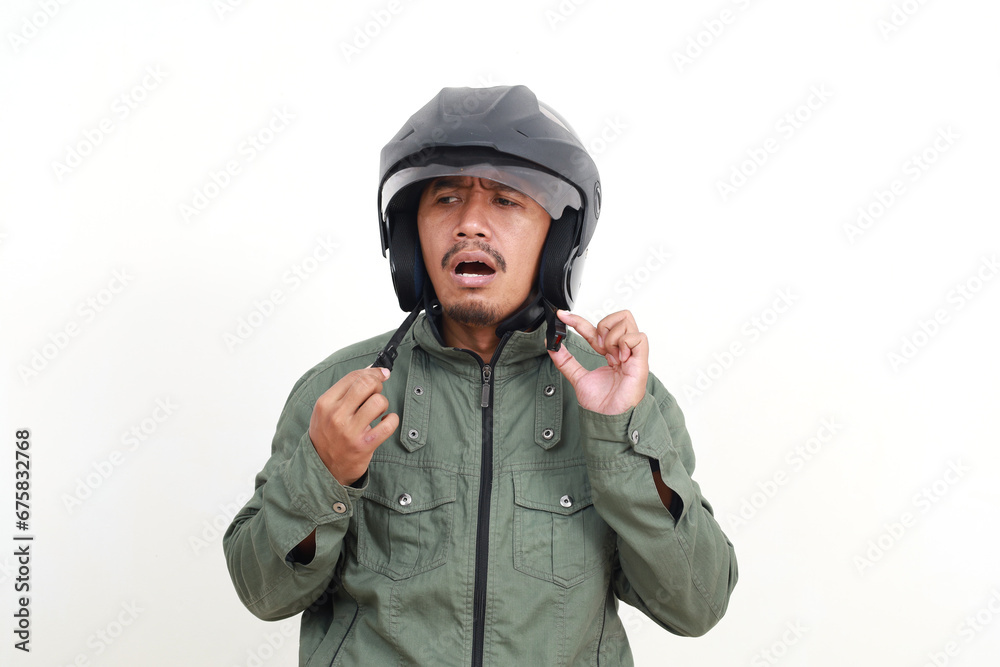 Stressed asian man standing while wearing helmet. Isolated on white background Stressed asian man standing while wearing helmet. Isolated on white background