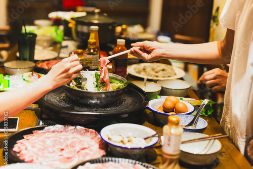 Group of friends cooking the Chinese shabu hotpot at home. photo