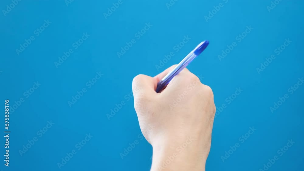 A ballpoint pen writes on a blue background A ballpoint pen writes on a blue background