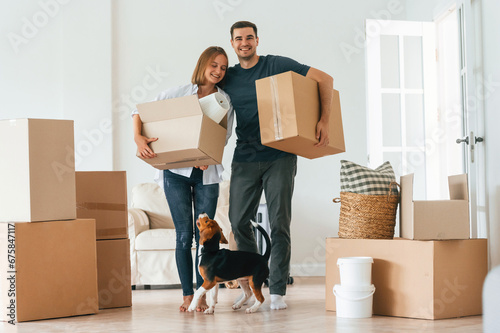 Bright big appartment. Young couple with dog are moving to new home © standret