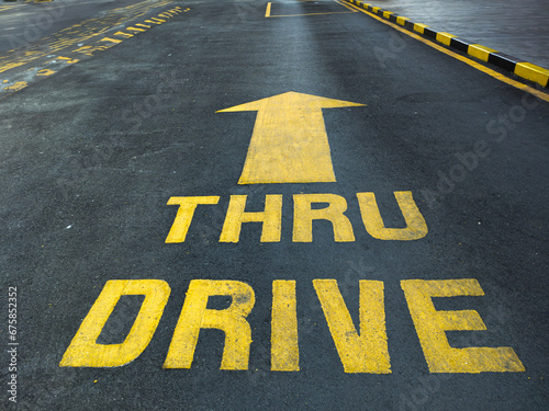 Asphalt road with yellow drive-thru signage © David