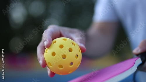 Pickleball player practiving to serve a ball with a paddle racket in slow motion video clip