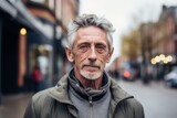 Portrait of a senior man with grey hair in the city.