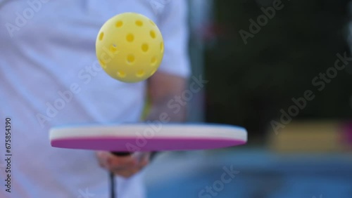 Pickleball player juggling with a ball in slow motion