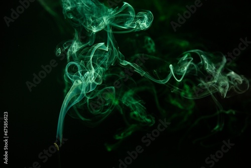 Ethereal image of green smoke in a dark environment