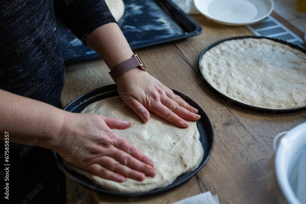 Φωτογραφία Woman kneading dough on a wooden table illuminated by natural light