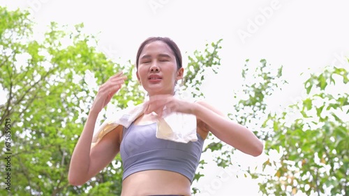 Sport asian woman gets tired and get dizzy, feel bad pain and suffer from heat stroke outdoors when jogging or exercise outdoor with strong sunlight in summer season. Heatstroke and heat wave concept.
