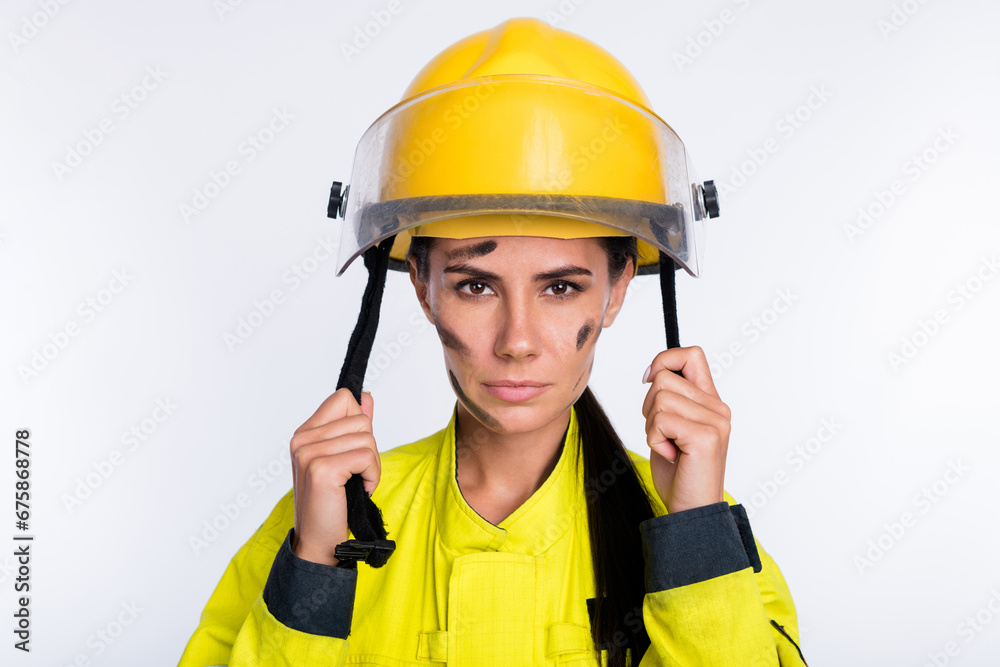 Photo of young attractive woman firefighter serious confident hands touch helmet isolated over white color background Photo of young attractive woman firefighter serious confident hands touch helmet isolated over white color background