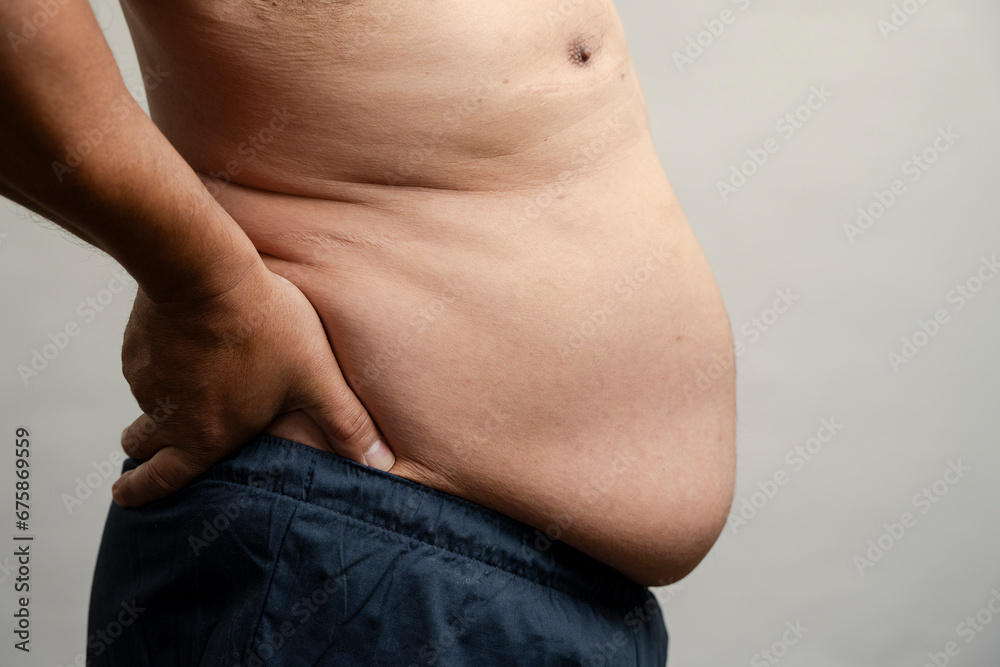 Naklejka premium Profile view of man with pot belly against gray background