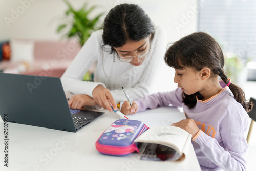 Girl helping little sister doing homework photo