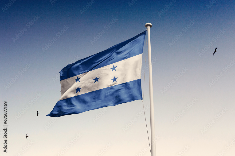 Fototapeta premium Honduras flag fluttering in the wind on sky.