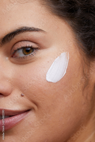 Obraz na plátně Close-up of young woman applying face cream