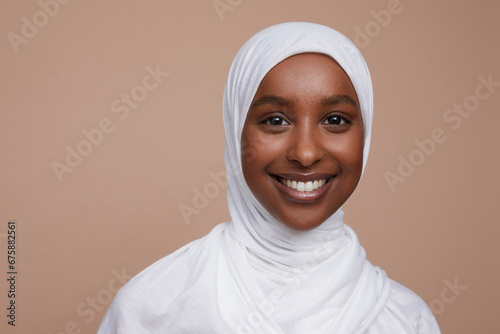 Studio portrait of smiling young woman wearing white hijab