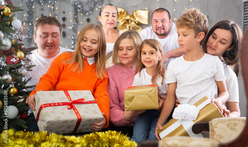 Family with children holding gifts in christmas interior