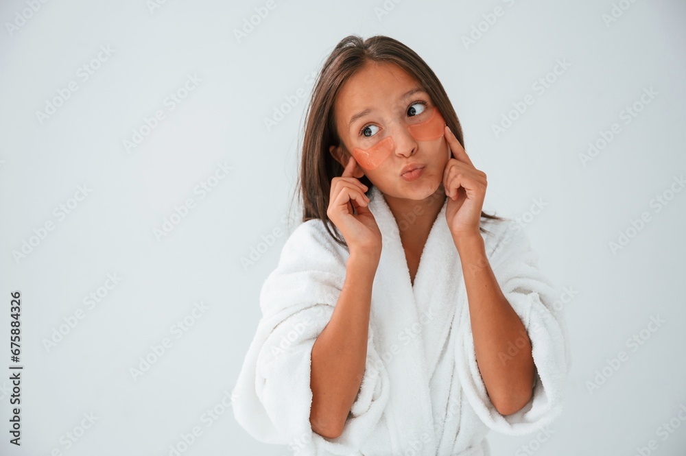 Playful mood. With eye patches. Conception of beauty and self care. Young girl is in the studio Playful mood. With eye patches. Conception of beauty and self care. Young girl is in the studio